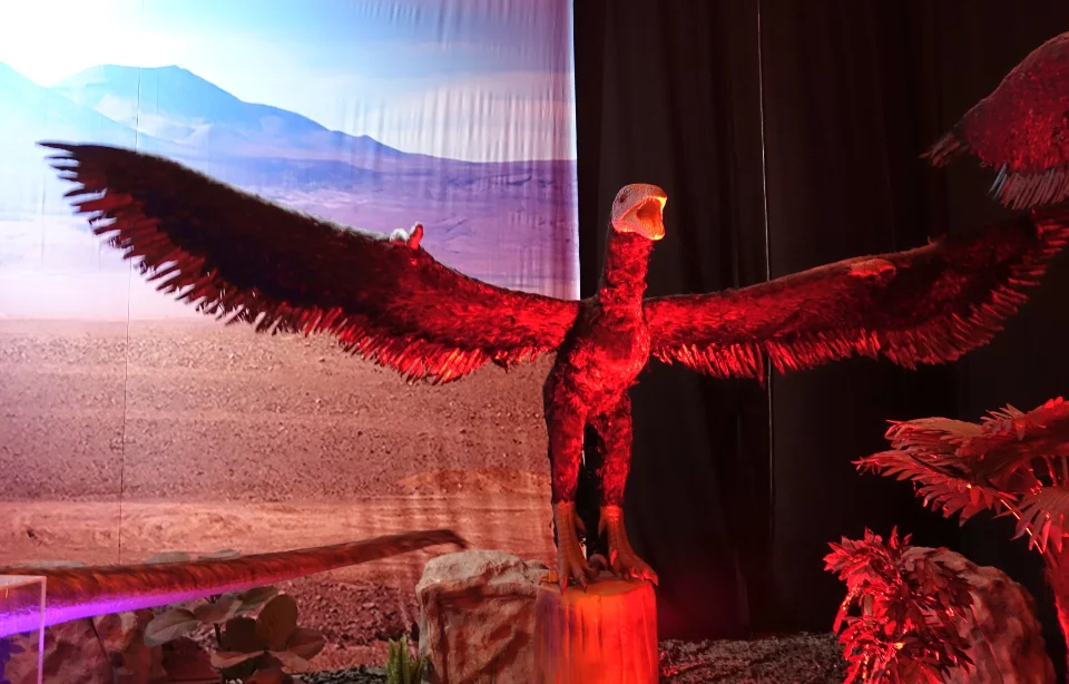 Ein kleiner Raptor der seine mt Fern bedeckten Vorderbeine seitlich ausstreckt